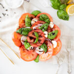 Caprese salad on a plate with tomato, basil, mozzarella and balsamic