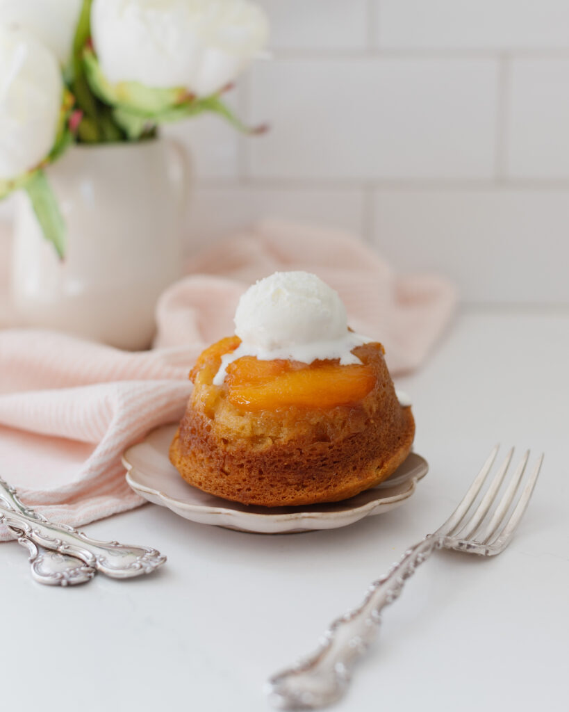 mini peach upside down cake on a plate with ice cream scoop