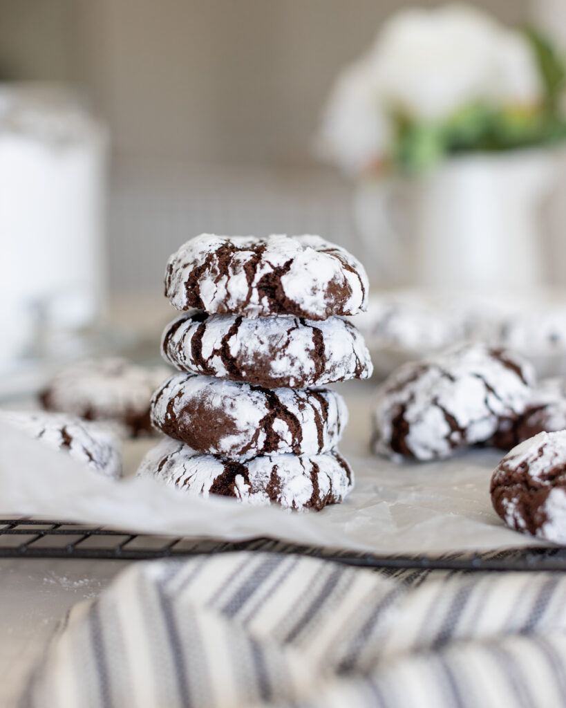 Chocolate Crinkle Cookies with baking sugar on the outside, stacked nigh on a baking tray