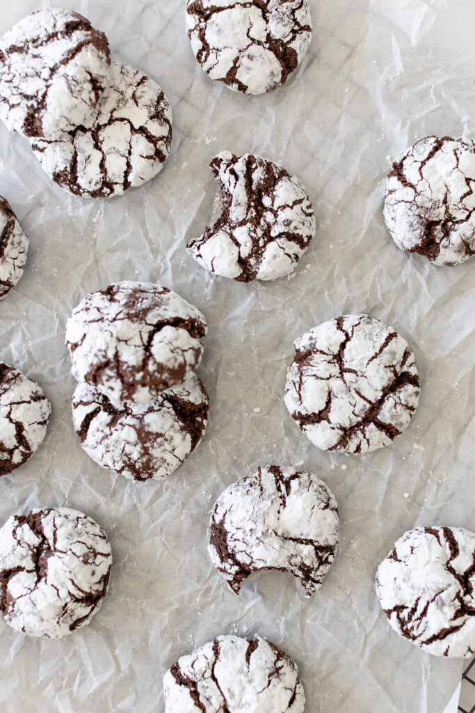 Chocolate Crinkle Cookies with baking sugar on the outside, stacked nigh on a baking tray