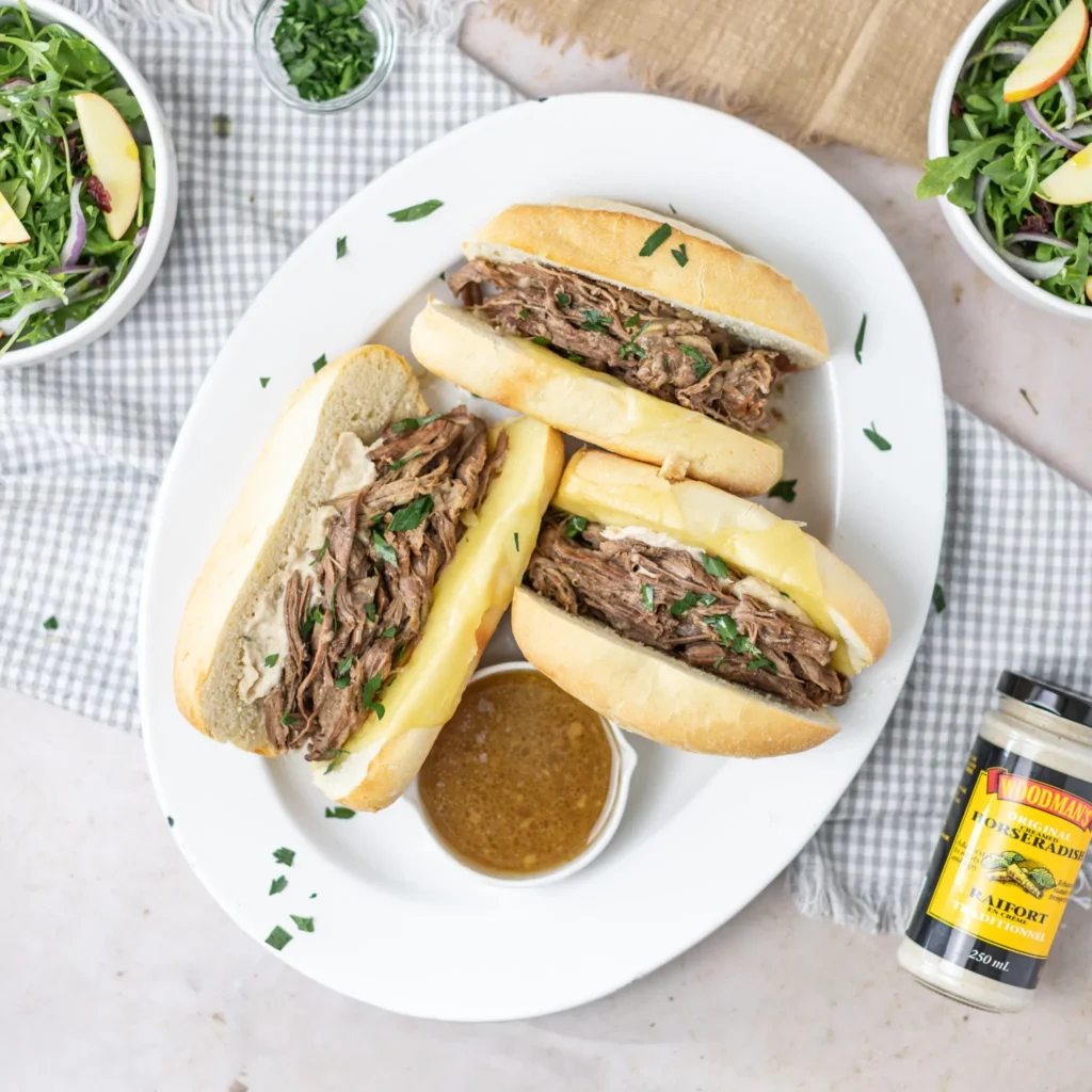 Fraiche Table Slow Cooker French Dips on a plate with a side of gravy