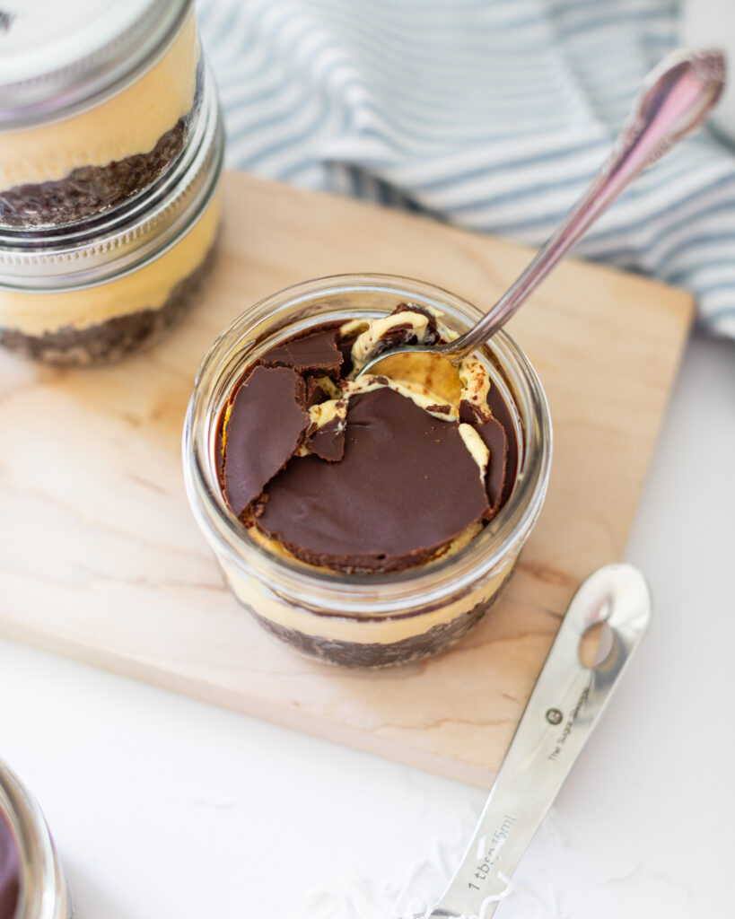 a spoon inside of a No-Bake Nanaimo Bar Cheesecake Jars