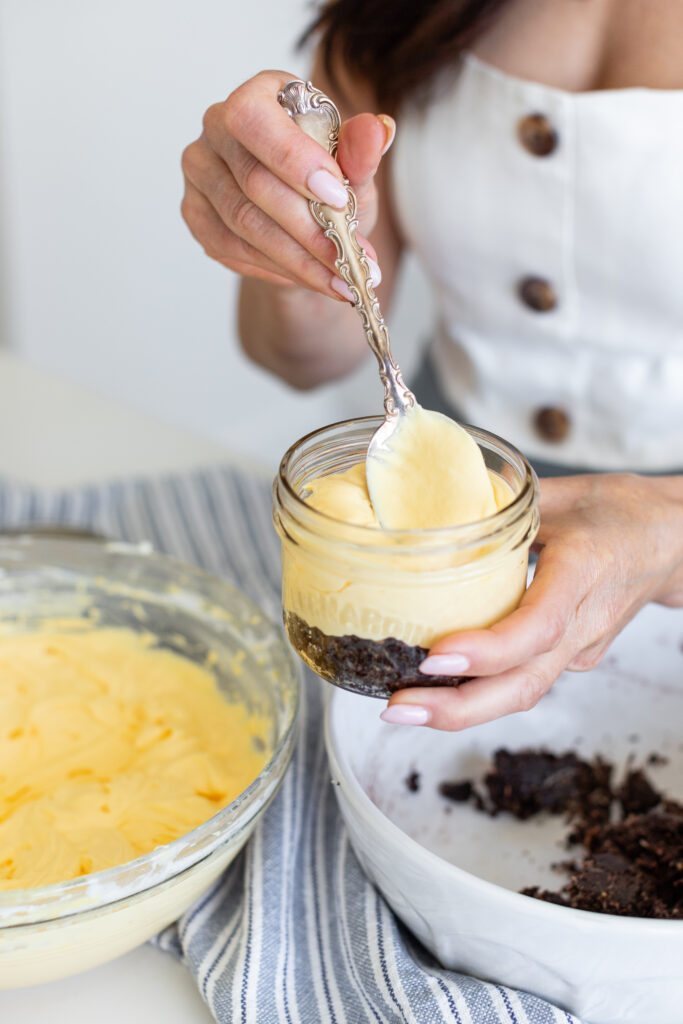 assembling the filling into a jar for the No-Bake Nanaimo Bar Cheesecake Jars recipe