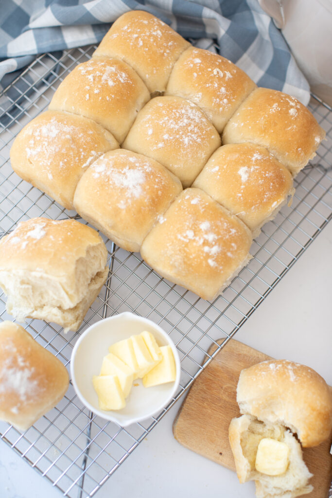 Perfect White Buns with butter on a cooling rack