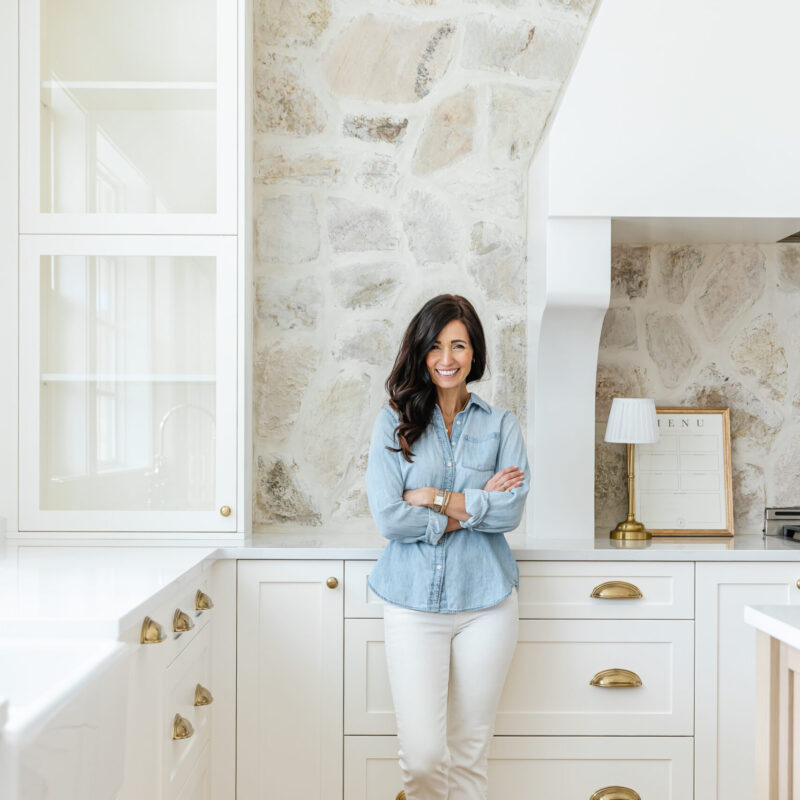 Woman in front of rock kitchen backsplash