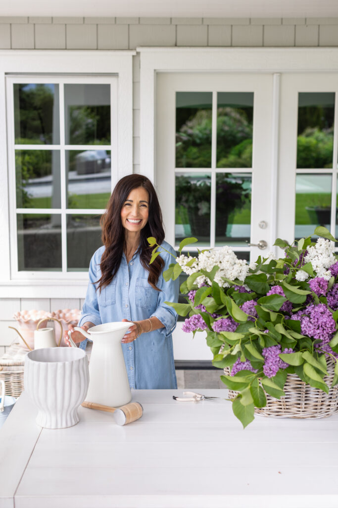 Tori standing with a fresh vase of French Garden Lilacs