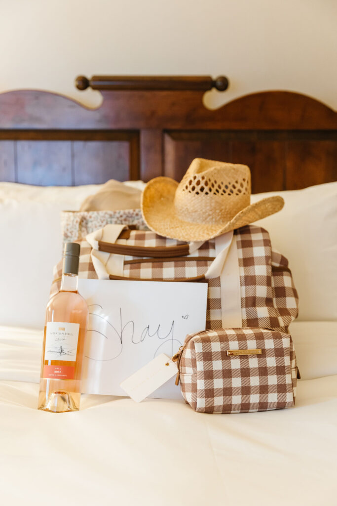Custom bachelorette swag bags with cozy sweatshirts, wine, beauty products, and cowboy hats for the Jasper celebration.