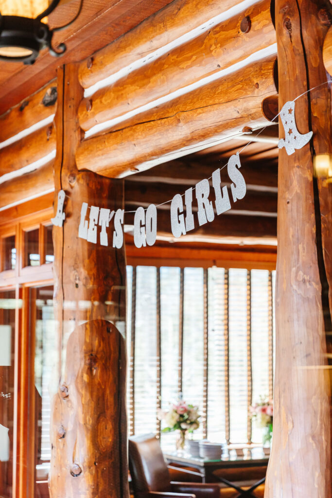 "Let's Go Girls" sign and décor set up at the cabin for a themed Jasper bachelorette weekend
