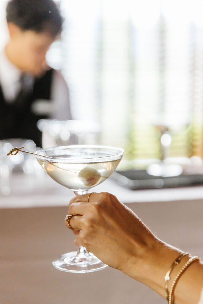 hand holding a martini with olives