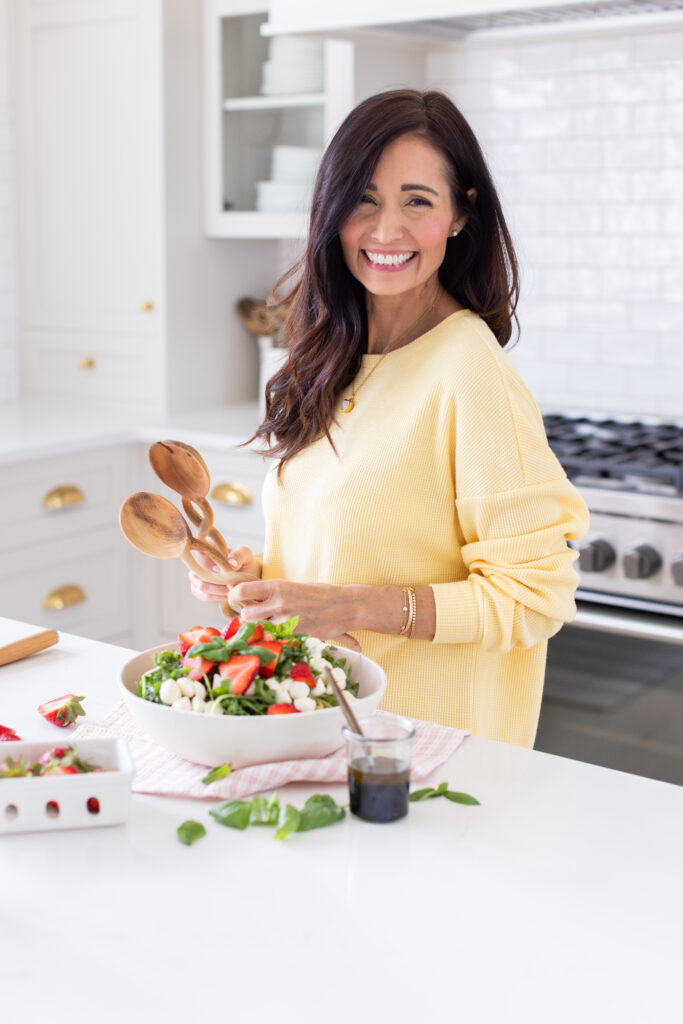 Tori holding bowl of Strawberry Caprese Pasta Salad