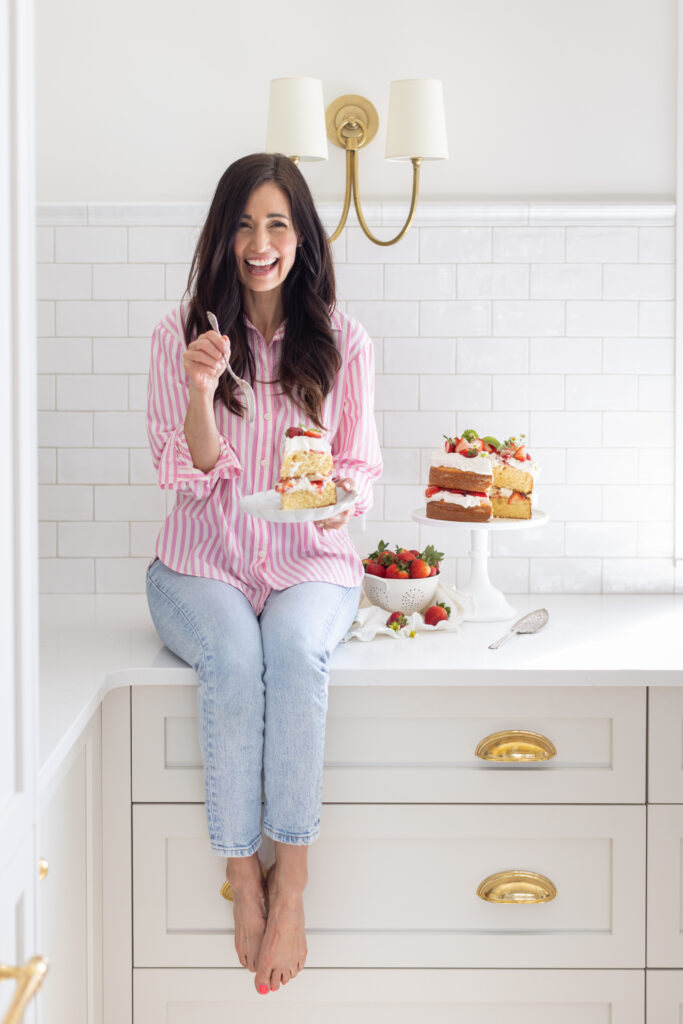 Tori sitting on counter with a piece of Strawberry Shortcake Cake on a plate