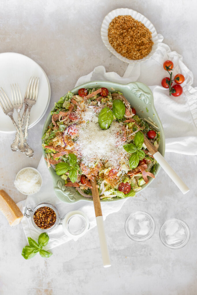 Overhead shot of Pizza Ranch Salad in a large bowl, topped with pepperoni, and shredded cheese.