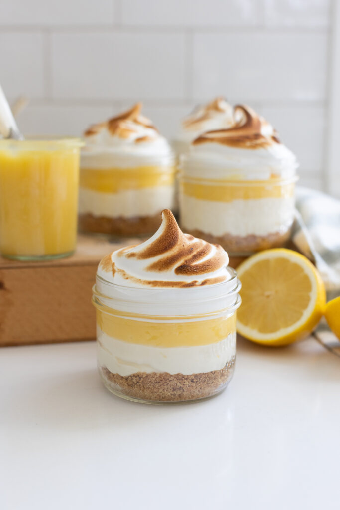 Lemon Meringue Cheesecake Jars topped with toasted meringue and lemon curd served in glass jars